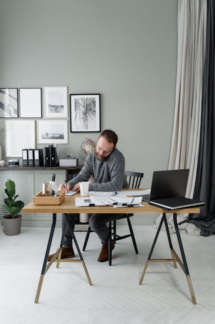 A focused person working on a laptop in a well-lit, organized workspace.